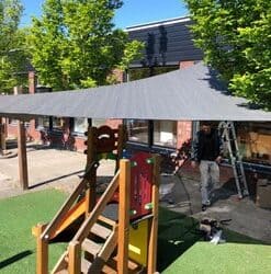 Een Shadow Comfort schaduwdoek driehoek boven een speelplaats
